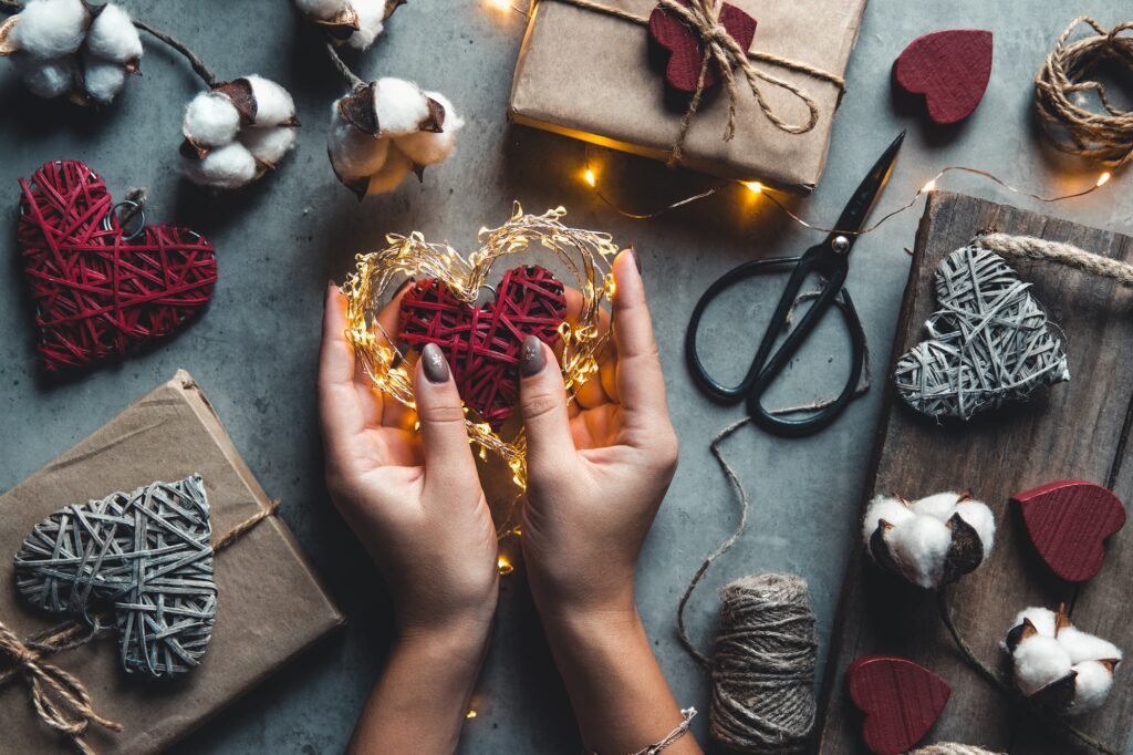 Close up on female hands holding a gift in a pink heart presents for valentine day