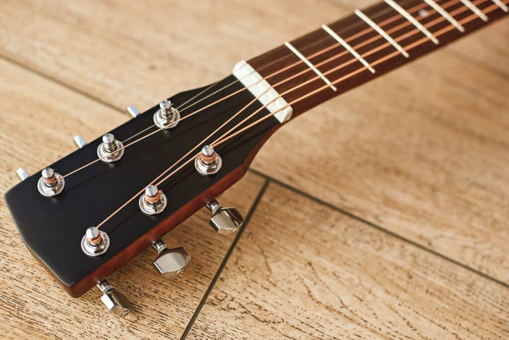 Uppermost part of the guitar. Close view of guitar headstock with tuning keys for adjusting guitar